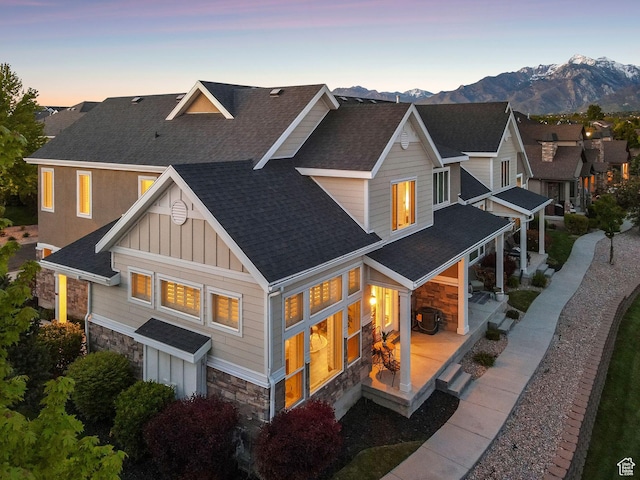 82 E Danta Dr S, Draper, UT 84020 - back of property with stone siding, board and batten siding, a shingled roof, a mountain view, and a patio area