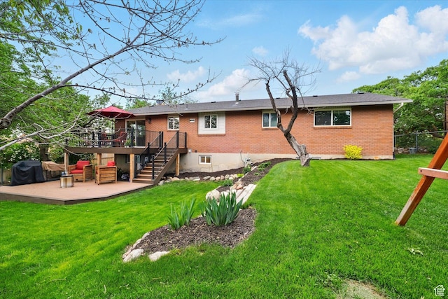 back of house featuring stairway, a wooden deck, and brick siding