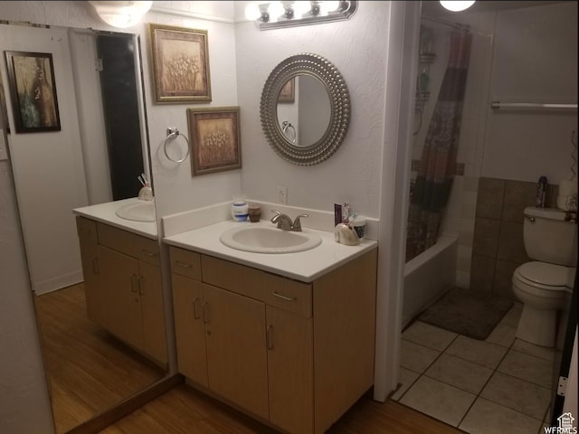 full bath featuring toilet, vanity, wood finished floors, and shower / tub combo with curtain