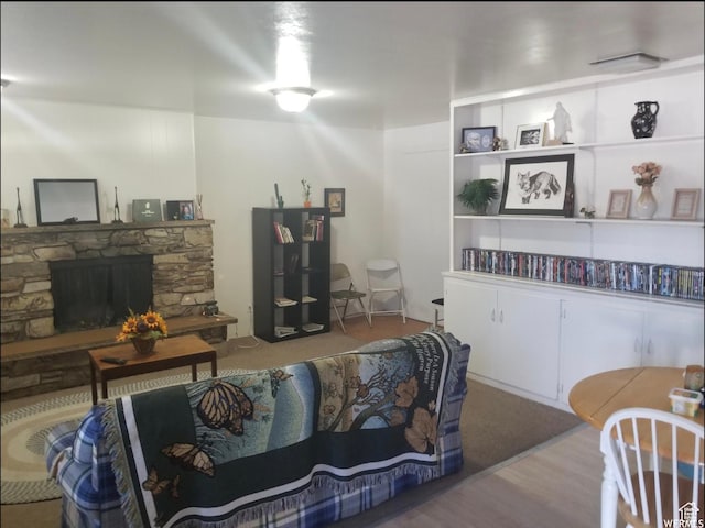 living area featuring wood finished floors and a stone fireplace