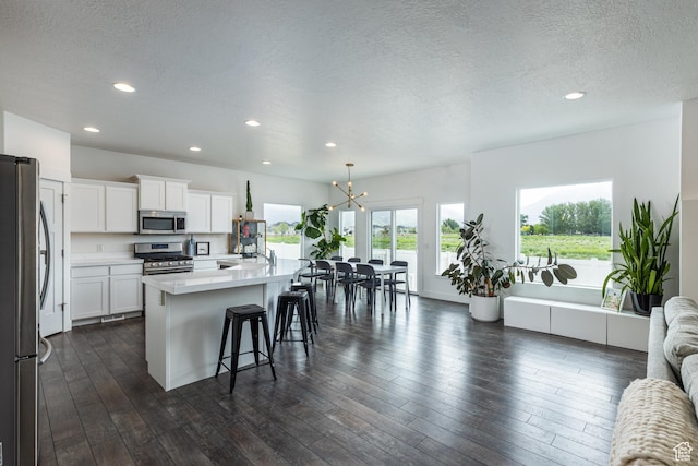 57 S Sterling Way, Vineyard, UT 84059 - kitchen with appliances with stainless steel finishes, recessed lighting, a breakfast bar, light countertops, and a chandelier