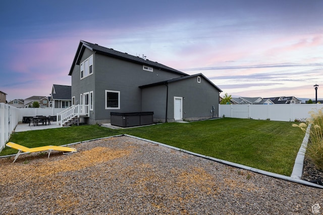 57 S Sterling Way, Vineyard, UT 84059 - back of house at dusk featuring a hot tub, a patio, and stucco siding