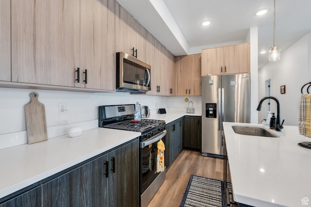 1218 S Sawmill Blvd Unit 1-106, Heber City, UT 84032 - kitchen with appliances with stainless steel finishes, a sink, light brown cabinetry, light countertops, and light wood-style flooring