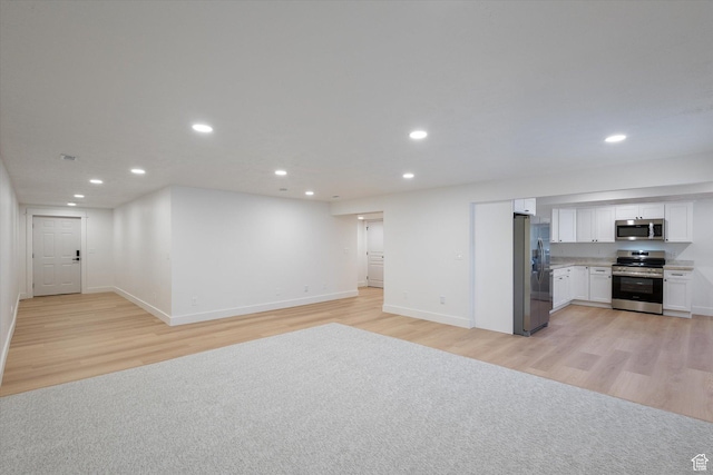 unfurnished living room featuring baseboards, light wood finished floors, and recessed lighting