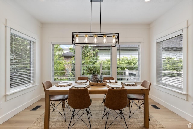 dining space with light wood-type flooring and baseboards