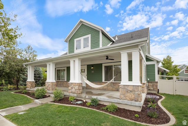craftsman-style house featuring stone siding, a porch, ceiling fan, and roof with shingles