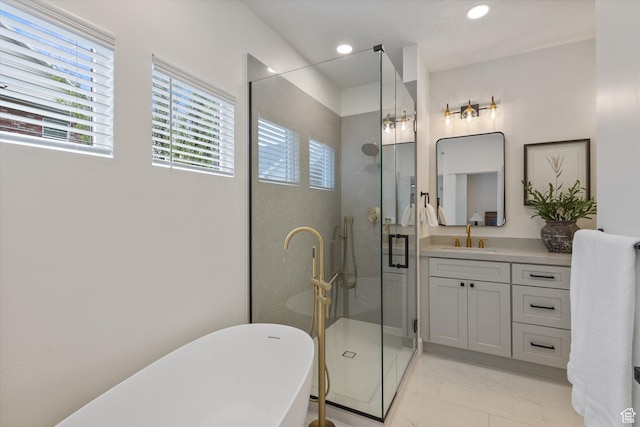 full bathroom featuring a shower stall, vanity, a soaking tub, marble finish floors, and recessed lighting