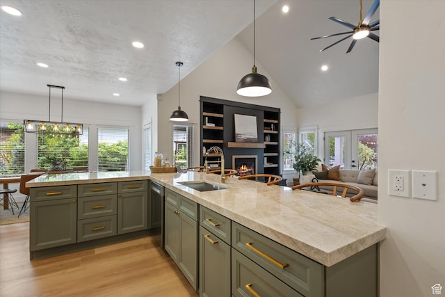 kitchen with open floor plan, stainless steel dishwasher, plenty of natural light, recessed lighting, and a warm lit fireplace
