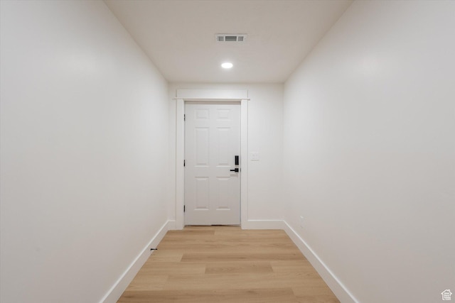 hallway with light wood-style floors, baseboards, and recessed lighting