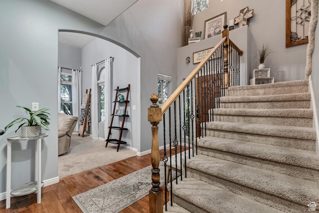 5414 W Island Creek Dr S, West Jordan, UT 84081 - stairway with arched walkways, wood finished floors, baseboards, and a high ceiling