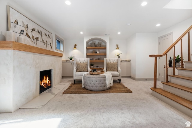 carpeted living room with recessed lighting, stairway, a premium fireplace, built in shelves, and baseboards