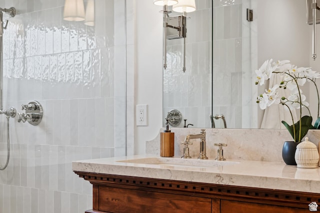 bathroom featuring a tile shower and vanity
