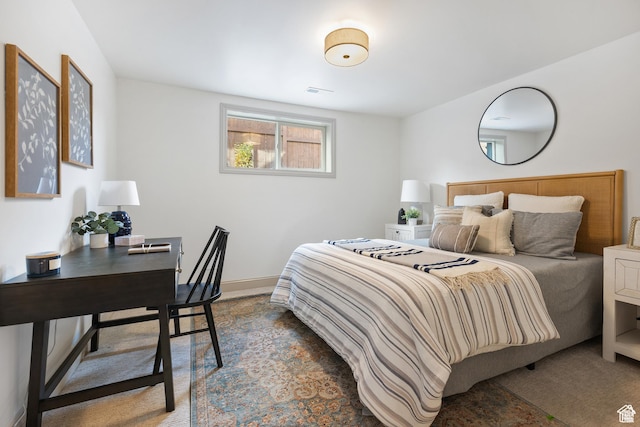 bedroom with an office area and baseboards