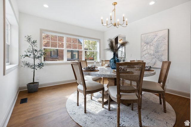 dining room with wood finished floors, a chandelier, baseboards, and recessed lighting