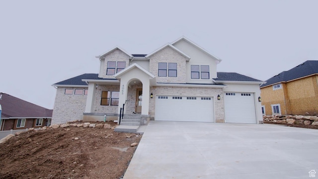 view of front facade featuring concrete driveway, a garage, and stone siding