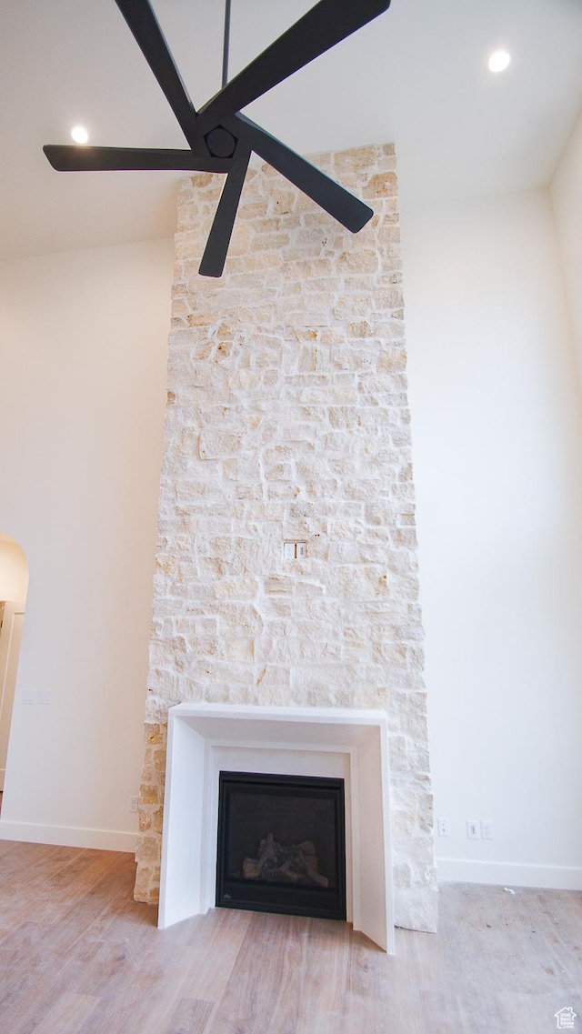 detailed view of wood finished floors, a ceiling fan, a fireplace, baseboards, and recessed lighting
