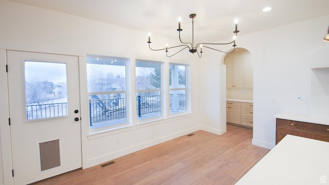unfurnished dining area featuring light wood finished floors, plenty of natural light, baseboards, a chandelier, and recessed lighting