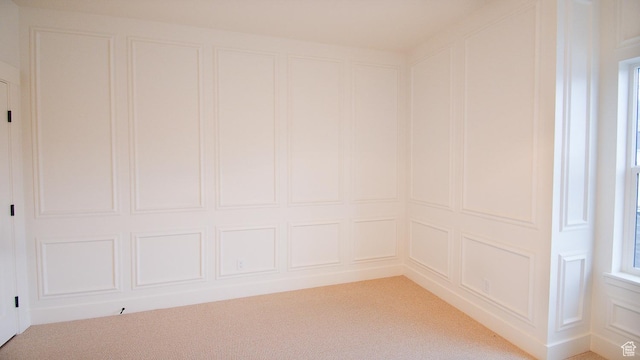 empty room with a decorative wall and light colored carpet