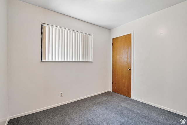 unfurnished room with carpet flooring and baseboards