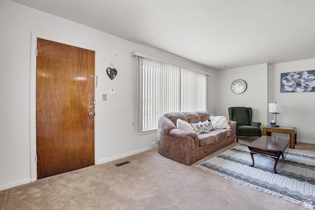 carpeted living area with baseboards
