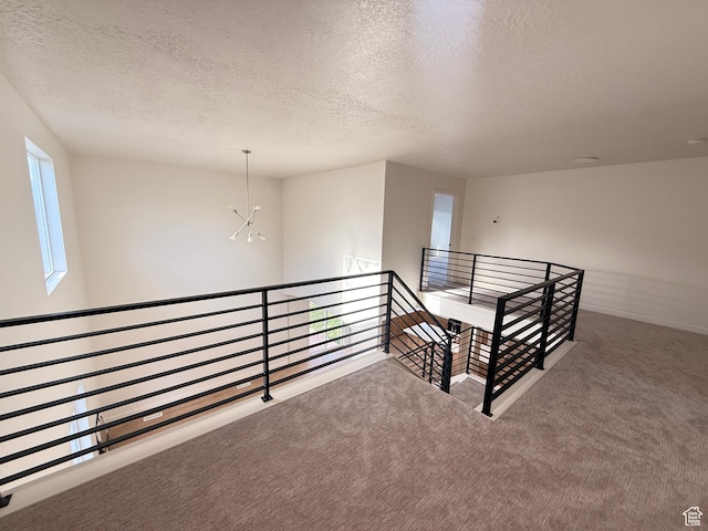 7038 W 8090 S, West Jordan, UT 84081 - hall featuring an upstairs landing, a textured ceiling, carpet, a chandelier, and baseboards