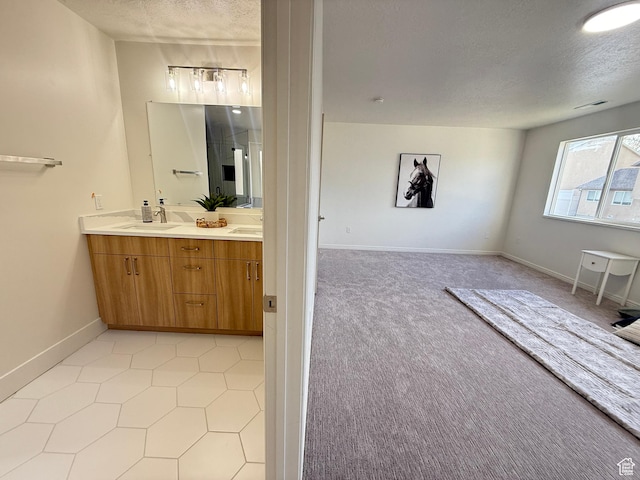 7038 W 8090 S, West Jordan, UT 84081 - bathroom featuring a textured ceiling, double vanity, baseboards, and tile patterned flooring