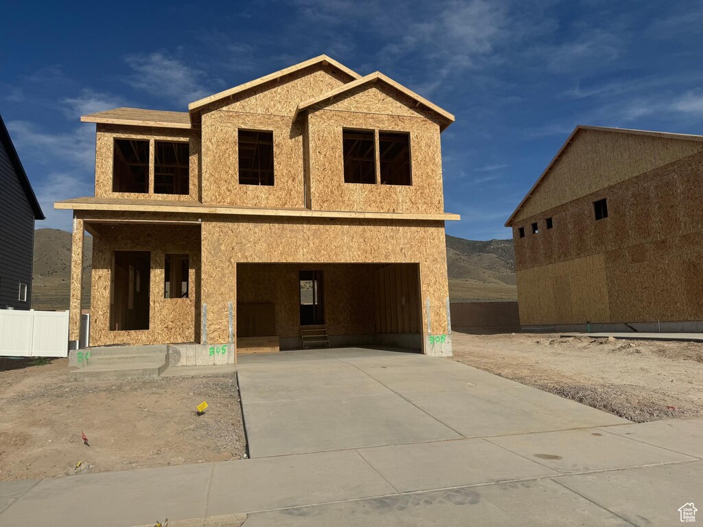 property under construction with concrete driveway, a garage, and a mountain view