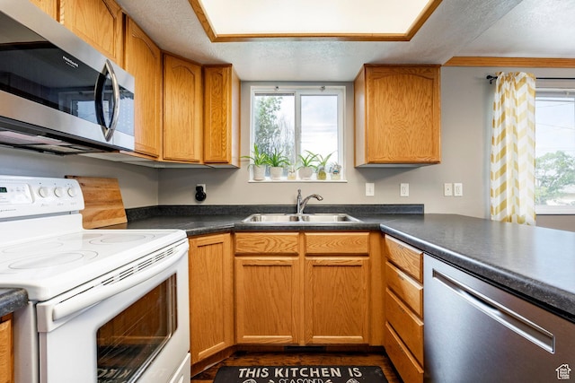 2135 W 4300 S, Roy, UT 84067 - kitchen with stainless steel appliances, plenty of natural light, a sink, a textured ceiling, and dark countertops