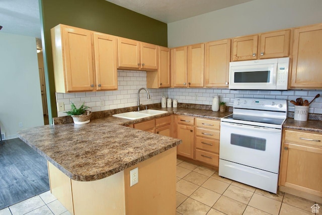kitchen featuring white appliances, light brown cabinets, a sink, and backsplash