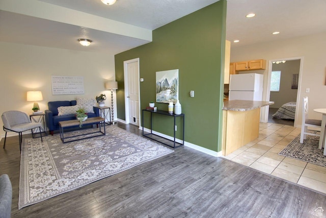 living area with light wood-type flooring and baseboards