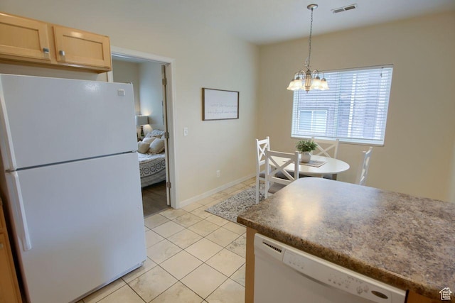 kitchen featuring white appliances, a chandelier, light tile patterned floors, hanging light fixtures, and light brown cabinetry