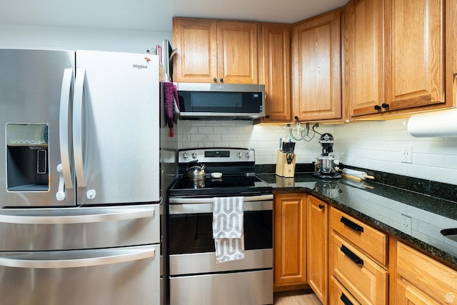 1088 N Nayon Dr Unit B, Layton, UT 84040 - kitchen featuring appliances with stainless steel finishes, backsplash, dark stone countertops, and brown cabinetry