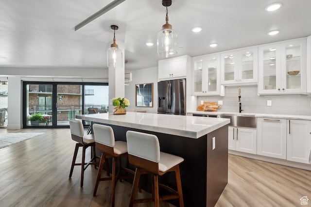 900 S Donner Way E Unit 707, Salt Lake City, UT 84108 - kitchen featuring stainless steel fridge, a center island, light wood-style floors, light stone counters, and recessed lighting