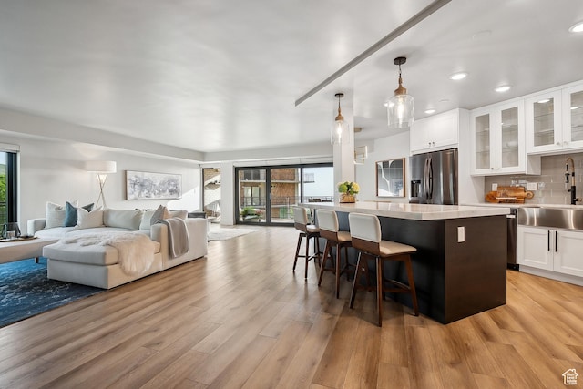 900 S Donner Way E Unit 707, Salt Lake City, UT 84108 - kitchen with stainless steel refrigerator with ice dispenser, healthy amount of natural light, open floor plan, white cabinetry, and recessed lighting