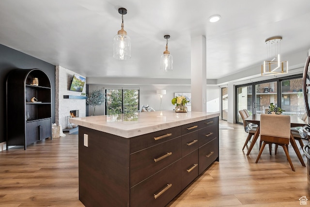 900 S Donner Way E Unit 707, Salt Lake City, UT 84108 - kitchen with light wood-style floors, pendant lighting, dark brown cabinetry, and modern cabinets
