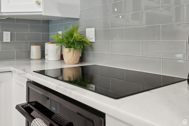 900 S Donner Way E Unit 707, Salt Lake City, UT 84108 - kitchen view of backsplash, light countertops, wall oven, and white cabinets