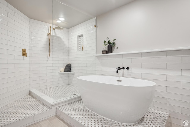 900 S Donner Way E Unit 707, Salt Lake City, UT 84108 - full bath featuring tile walls, a freestanding bath, a tile shower, and recessed lighting