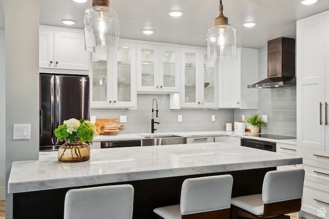 900 S Donner Way E Unit 707, Salt Lake City, UT 84108 - kitchen with wall chimney exhaust hood, freestanding refrigerator, a breakfast bar, light stone counters, and recessed lighting