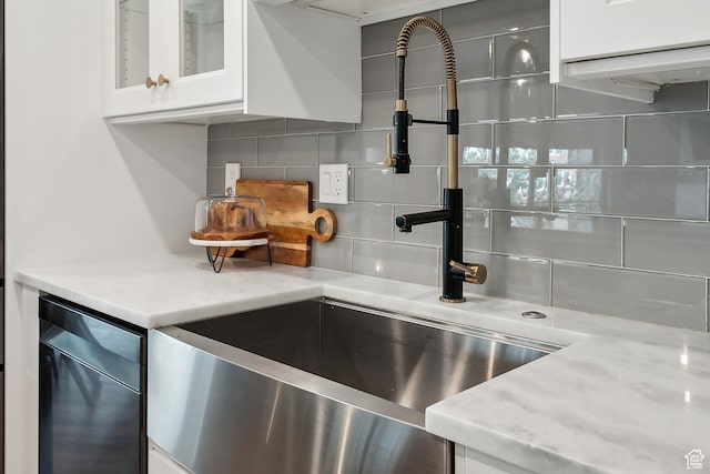 900 S Donner Way E Unit 707, Salt Lake City, UT 84108 - kitchen view of tasteful backsplash, white cabinetry, glass insert cabinets, and light stone counters
