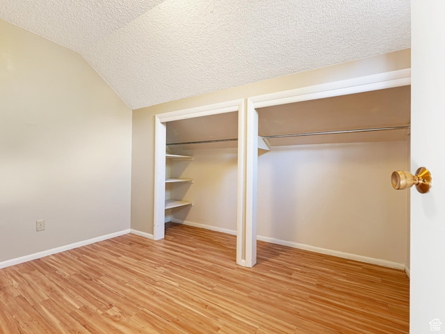 450 W Chokecherry Cir, Orem, UT 84058 - unfurnished bedroom with a textured ceiling, vaulted ceiling, light wood finished floors, baseboards, and multiple closets