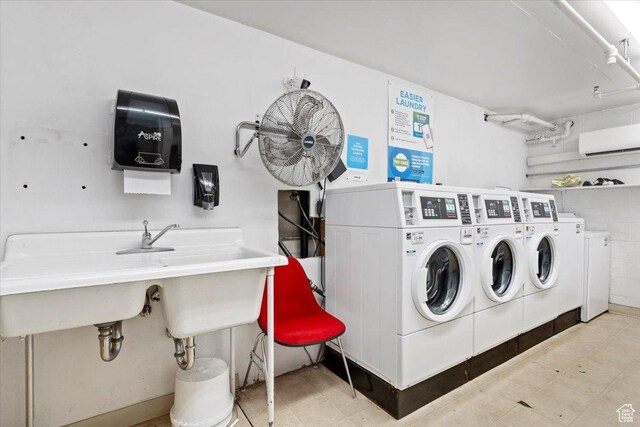 community laundry featuring independent washer and dryer and a wall mounted AC