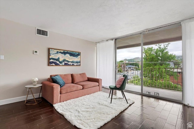 living room featuring wood tiled floors, floor to ceiling windows, and baseboards