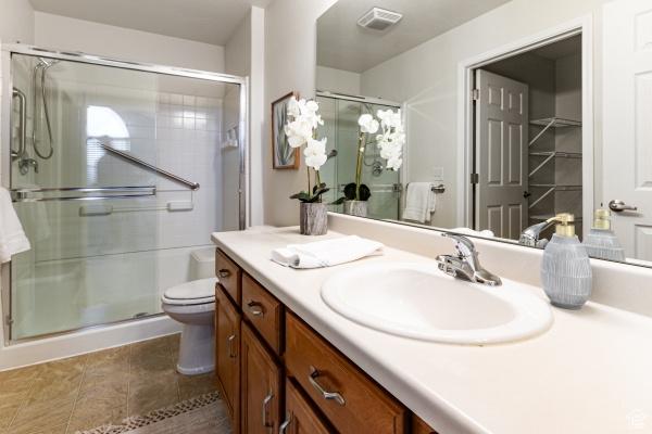 full bathroom with a stall shower, vanity, toilet, and tile patterned floors