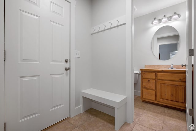 mudroom featuring a sink and light tile patterned flooring