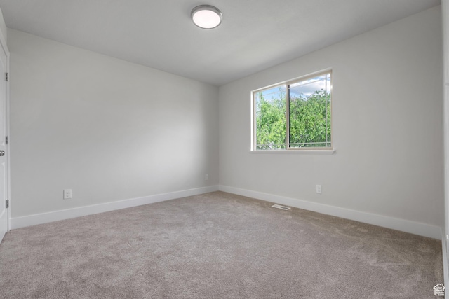 carpeted empty room featuring baseboards