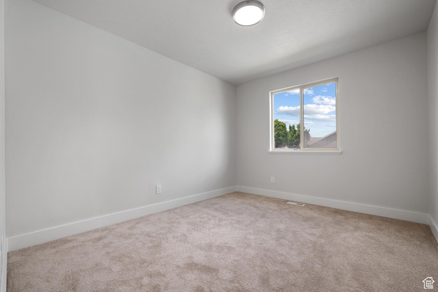 unfurnished room featuring carpet floors and baseboards