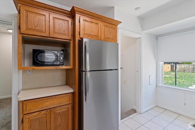 3214 Porter Ave, Ogden, UT 84403 - kitchen featuring freestanding refrigerator, black microwave, light countertops, and brown cabinetry