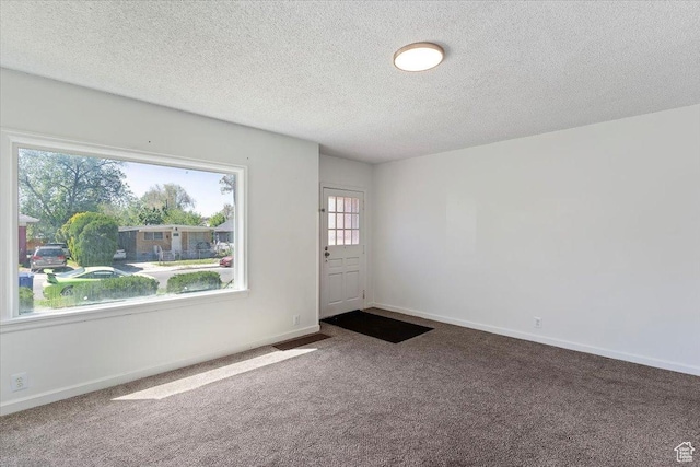 3214 Porter Ave, Ogden, UT 84403 - foyer entrance featuring dark colored carpet, a textured ceiling, and baseboards