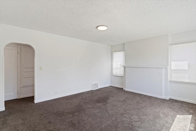 3214 Porter Ave, Ogden, UT 84403 - spare room featuring dark colored carpet, a textured ceiling, arched walkways, plenty of natural light, and baseboards