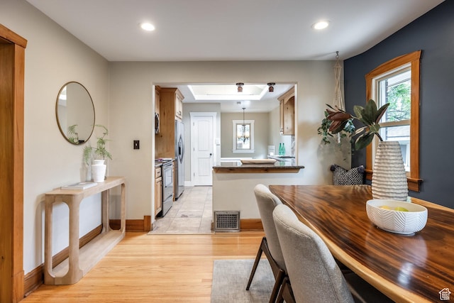 dining space with light wood-style floors, recessed lighting, and baseboards